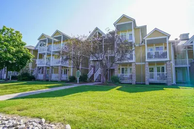 a large yellow building with a grass yard at Stunning Condo with Access to Pool in Shanty Bay