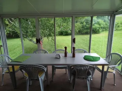 a table and chairs in a room with a large window at Cottage on the Pond in Millbrook