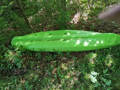 a green kayak sitting on the grass at Cottage on the Pond in Millbrook