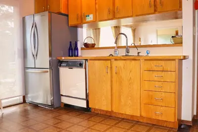 a kitchen with a refrigerator and a sink at Cottage on the Pond in Millbrook