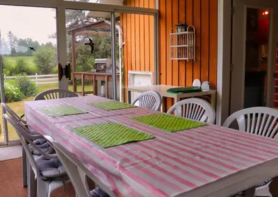 a dining room table with a pink and green table cloth at Cottage on the Pond in Millbrook