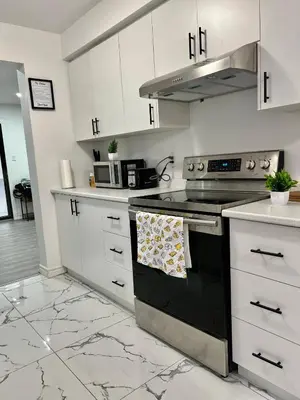 a kitchen with white cabinets and a stove top oven at K1 Private Bathroom Queen Bed Room in Mississauga