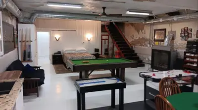 a living room with a pool table and a bed at Renovated Church Hamilton! Guest Suite in Hamilton