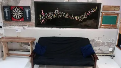 a room with a chair and a table and a painting at Renovated Church Hamilton! Guest Suite in Hamilton