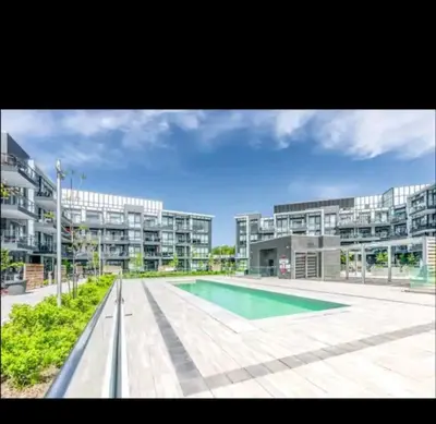 a large apartment building with a swimming pool at Nature trail view with cozy patio and firetable in Innisfil