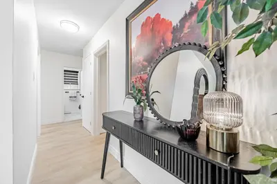 a mirror on a black dresser in a living room at Unique Oasis with Tri-City Access in Mississauga