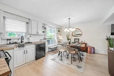 a kitchen with white cabinets and a table with chairs at Unique Oasis with Tri-City Access in Mississauga