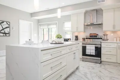 a white kitchen with white cabinets and appliances at Lake House By Lis in Innisfil