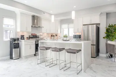 a kitchen with white cabinets and stainless steel appliances at Lake House By Lis in Innisfil
