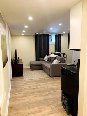 a living room with a couch and a table at Cozy 1 bedroom basement apartment 14 days minimum in Fonthill