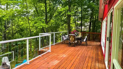 a deck with a table and chairs on a house at Summit Cottage on Kawagama Lake in Dorset