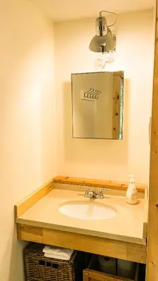 a bathroom with a sink and a mirror at Summit Cottage on Kawagama Lake in Dorset