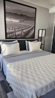 a bedroom with a large bed with a painting on the wall at Serenity Inn in Niagara Falls