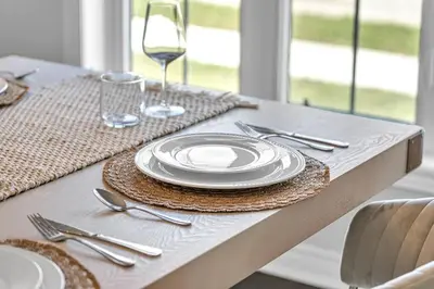a table with a white plate and a glass of wine at Lavish Home on Hamilton Mountain in Hamilton