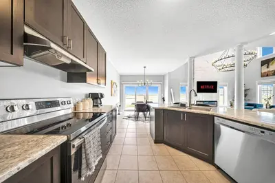 a kitchen with stainless steel appliances and a dining room at Lavish Home on Hamilton Mountain in Hamilton