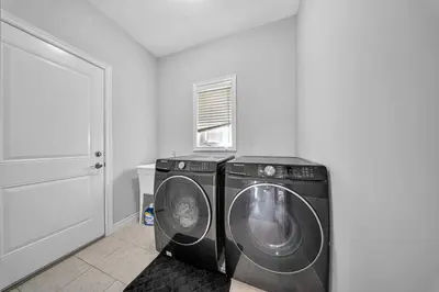 two washing machines in a room with a door at Lavish Home on Hamilton Mountain in Hamilton