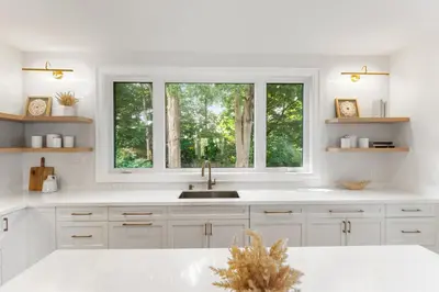 a white kitchen with a sink and two windows at Luxury Home - 5 min from airport, 15 to downtown in Toronto