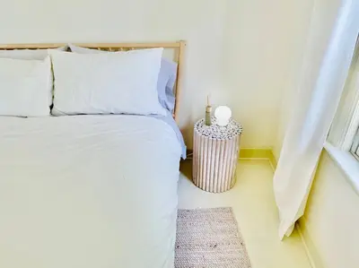 a bedroom with a bed with white sheets and a window at Waterfront Niagara-On-The-Lake Farmhouse on a Vineyard in Niagara on the Lake
