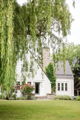 a white house with a tree in front of it at Waterfront Niagara-On-The-Lake Farmhouse on a Vineyard in Niagara on the Lake