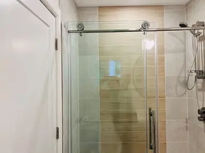 a shower with a glass door in a bathroom at Davi's Lake House in Torrance