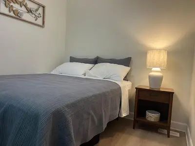 a bedroom with a bed and a table with a lamp at Davi's Lake House in Torrance
