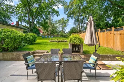a patio with a glass table with chairs and an umbrella at Queenston Cottage in Queenston