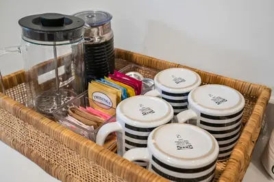 a wicker basket filled with coffee mugs and a jar at Queenston Cottage in Queenston
