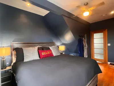a bedroom with a black bed with a red pillow on it at Sunset Suites in Niagara Wine Country in Niagara on the Lake