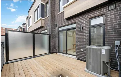 a balcony with a wooden deck in front of a brick building at Private Room M A P L E with Attached Full Bathroom in Toronto, ON, Canada in Toronto