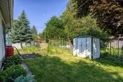 a garden with a small shed in the grass at New 2 bedroom basement apartment in Guelph