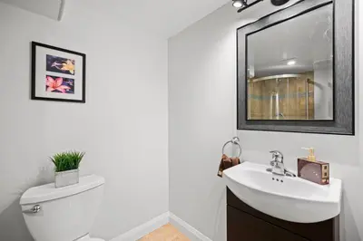 a bathroom with a sink and a toilet and a mirror at New 2 bedroom basement apartment in Guelph