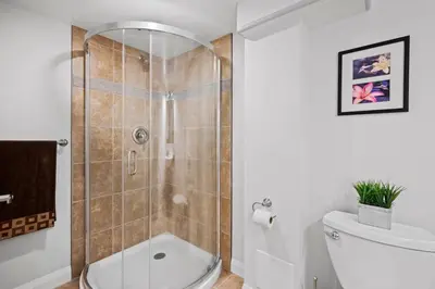 a bathroom with a shower with a toilet and a sink at New 2 bedroom basement apartment in Guelph