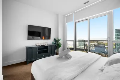 a white bedroom with a large bed and a flat screen tv at RentX 3Bedroom Penthouses near Rogers Centre & MTCC in Toronto