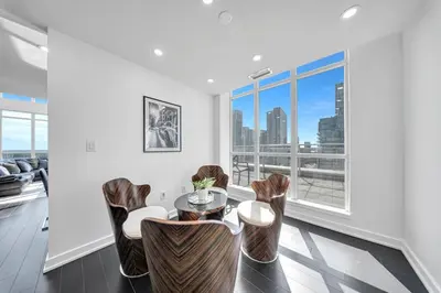 a living room with a table and chairs and a large window at RentX 3Bedroom Penthouses near Rogers Centre & MTCC in Toronto