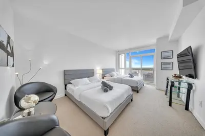 a bedroom with two beds and a desk and a chair at RentX 3Bedroom Penthouses near Rogers Centre & MTCC in Toronto