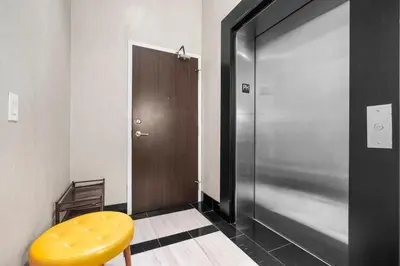 a hallway with a yellow stool next to a door at RentX 3Bedroom Penthouses near Rogers Centre & MTCC in Toronto