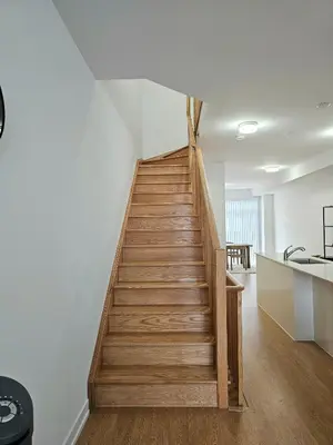a staircase in a home with white walls and wooden floors at CEDAR Double Room with attached private Bathroom and Balcony in Toronto, ON, Canada in Toronto