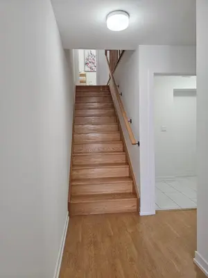 a staircase in a home with white walls and wooden floors at CEDAR Double Room with attached private Bathroom and Balcony in Toronto, ON, Canada in Toronto