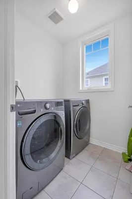 a washer and dryer in a room with a window at Entire 6BR 2 king 8 beds in total pets 3 GB WiFi in Kitchener
