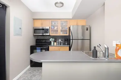 a kitchen with a sink and a refrigerator at Lakeside Haven - Cozy Townhome in Liberty Village in Toronto