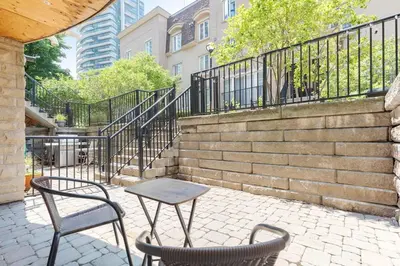 a table and two chairs on a patio with stairs at Lakeside Haven - Cozy Townhome in Liberty Village in Toronto