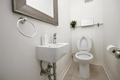 a white bathroom with a toilet and a mirror at Spacious Room with Ensuite Bathroom near Subway, Koreatown & UofT in Toronto