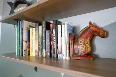 a book shelf with books and a horse statue at Spacious Room with Ensuite Bathroom near Subway, Koreatown & UofT in Toronto