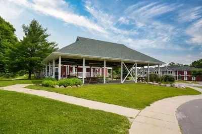 a red house with a gray roof on a lawn at King Bed, Balcony, Pool, Hot Tub, Sauna in Edgar