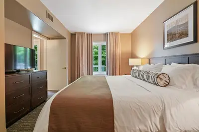 a bedroom with a large bed and a flat screen tv at King Bed, Balcony, Pool, Hot Tub, Sauna in Edgar