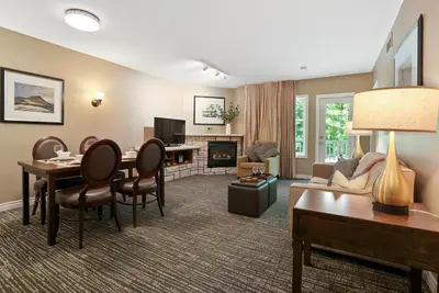 a living room with a table and chairs and a living room at King Bed, Balcony, Pool, Hot Tub, Sauna in Edgar