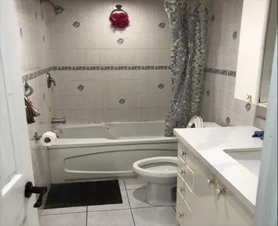 a bathroom with a bath tub and a toilet at SHAY-BASEMENT-Holiday Home in Pickering