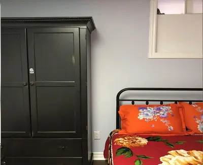 a bedroom with a bed and a black cabinet at SHAY-BASEMENT-Holiday Home in Pickering