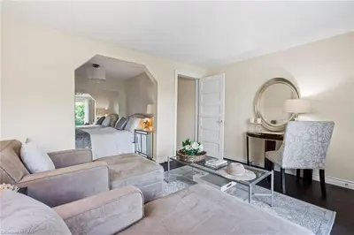 a living room with a couch and a bed with a mirror at Hummingbird Haven Bed & Breakfast Luxury Suite With Terrace & Seasonal Lake Views Located in Historic Old Town Niagara-On-The-Lake in Niagara on the Lake