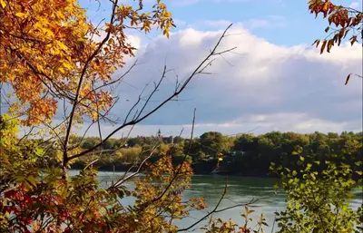 a view of a river with trees in the background at Hummingbird Haven Bed & Breakfast Luxury Suite With Terrace & Seasonal Lake Views Located in Historic Old Town Niagara-On-The-Lake in Niagara on the Lake